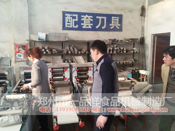 工作人員向安陽周先生介紹HMJ-5型燴面機的特點