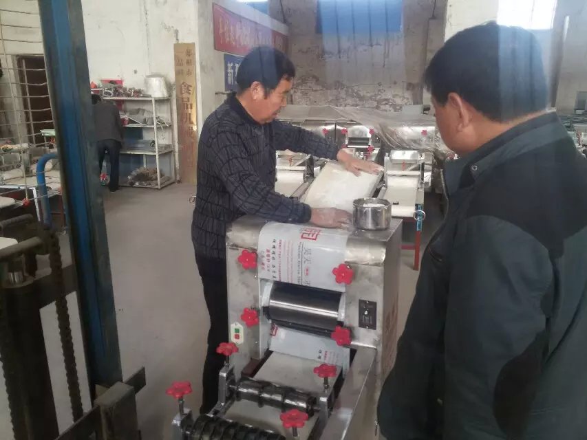 工作人員正在調(diào)試燴面機(jī)