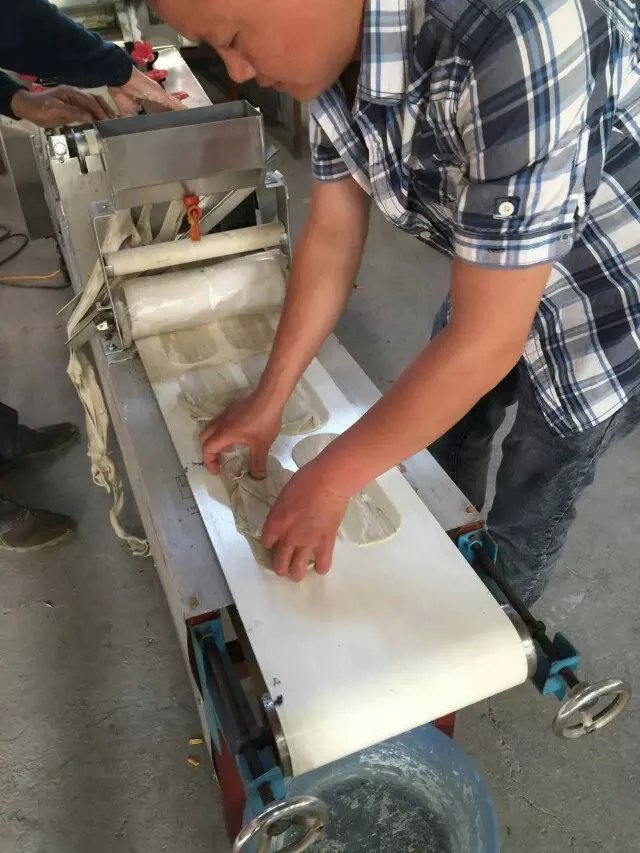 工作人員和王先生在車間進(jìn)行機(jī)器調(diào)試