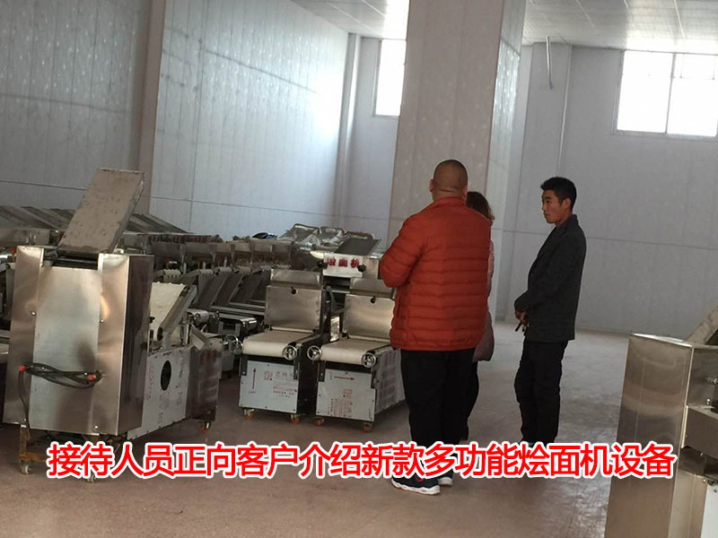 接待人員正向客戶介紹新款多功能燴面機(jī)設(shè)備